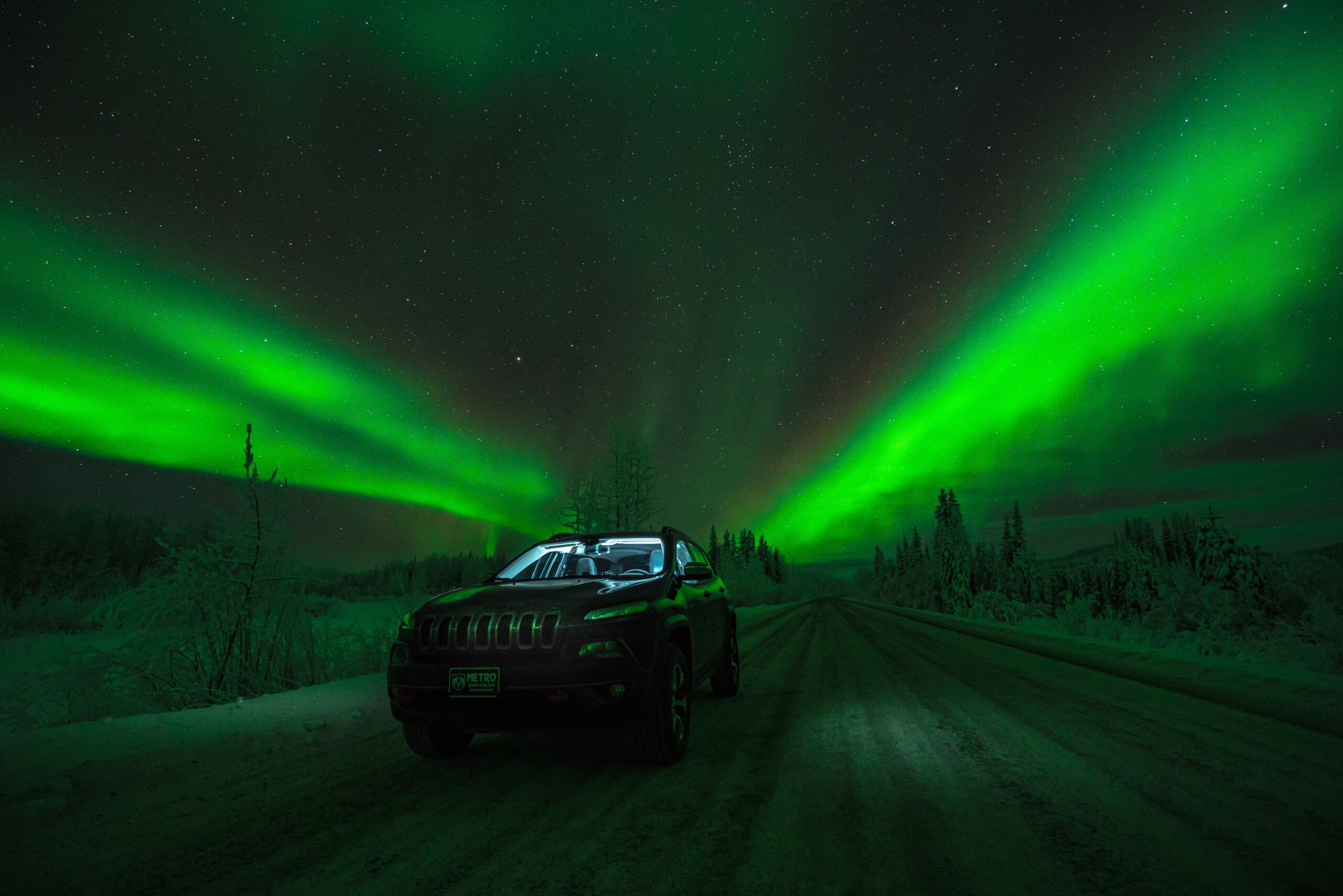 An SUV under the Northern Lights